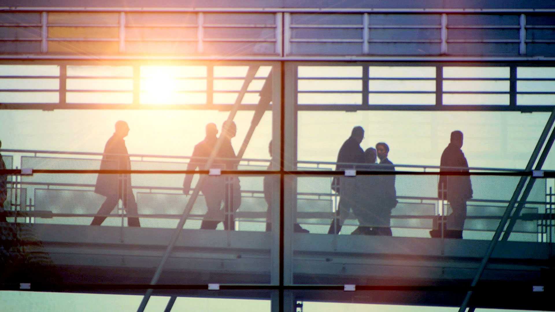 american commuters in a skybridge going to an office building