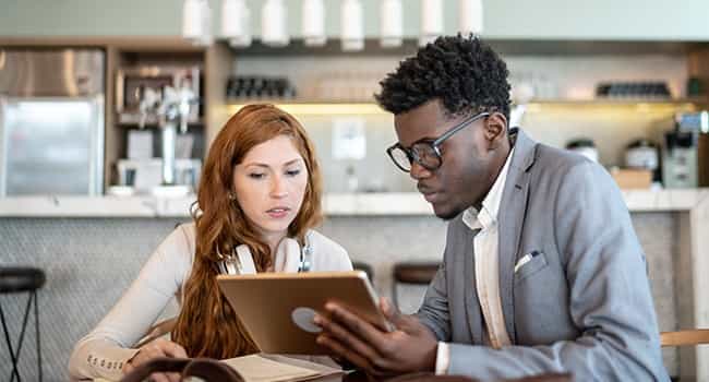 a real estate advisor discusses mortgage esrvices with a client in a modern cafe