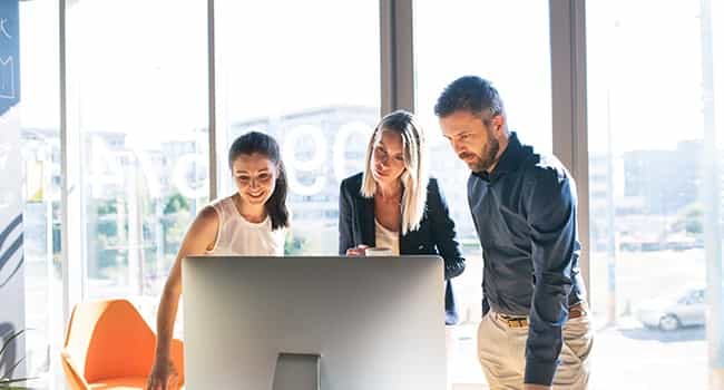 professionals review work on a computer monitor in a modern work environment