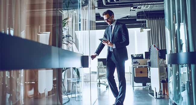 asset manager reviews real estate statistics on the way into a conference room in a high tech office suite