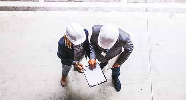 project manager discusses construction timeline with a client in a real estate development