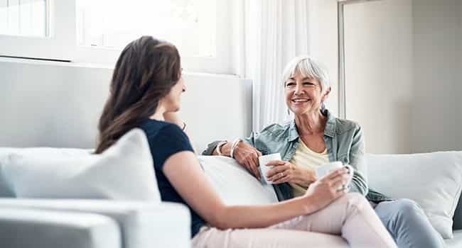 friends discuss senior housing on a couch in a modern apartment