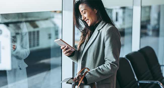 a real estate professionals views market data on a tablet while standing in the lobby of an office building
