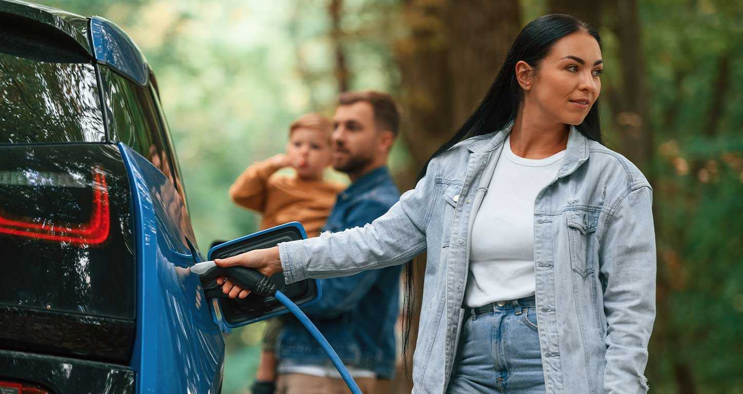 a woman charges an EV