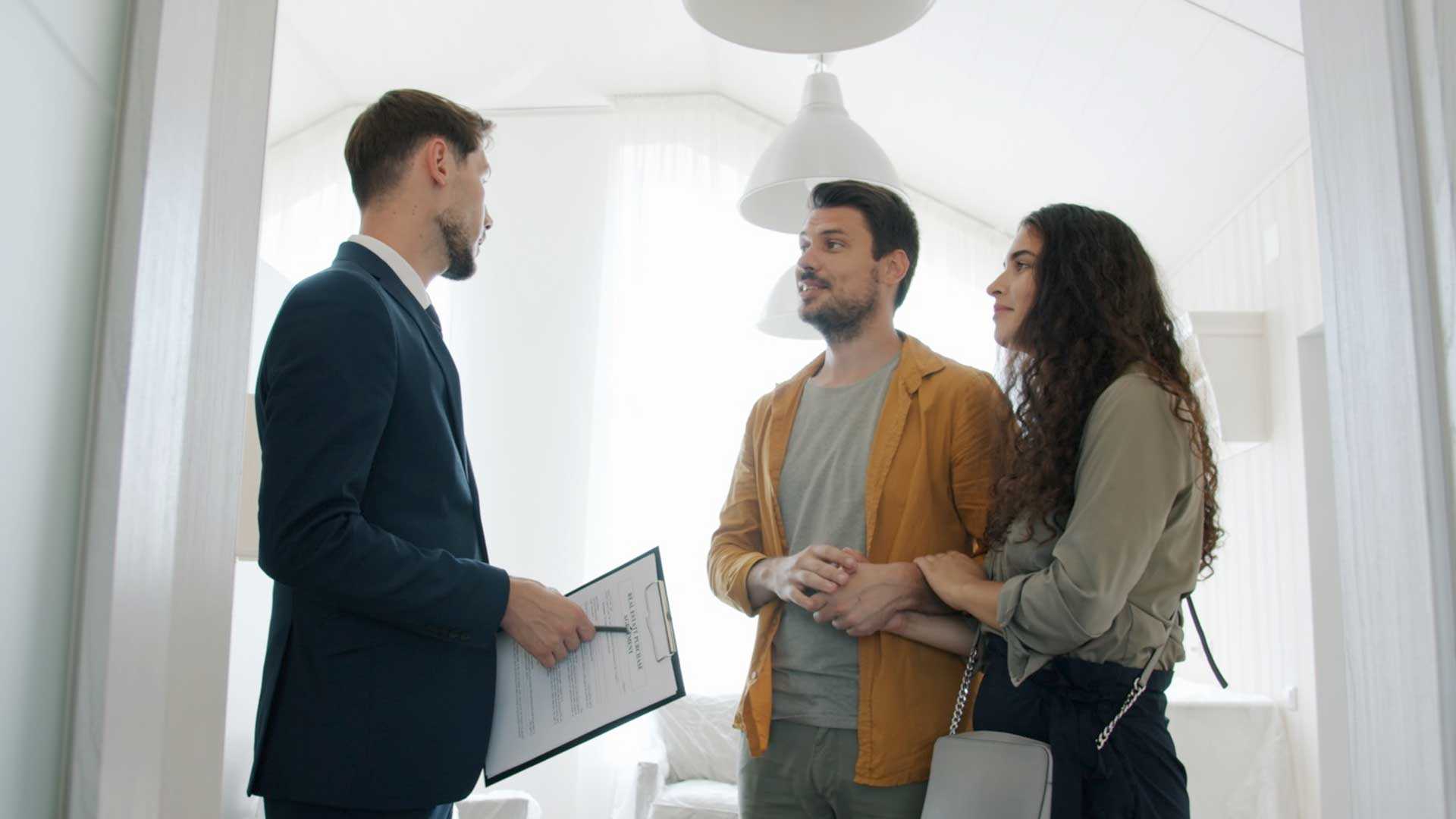 a couple speaks to a leasing agents in a multifamily residential unit