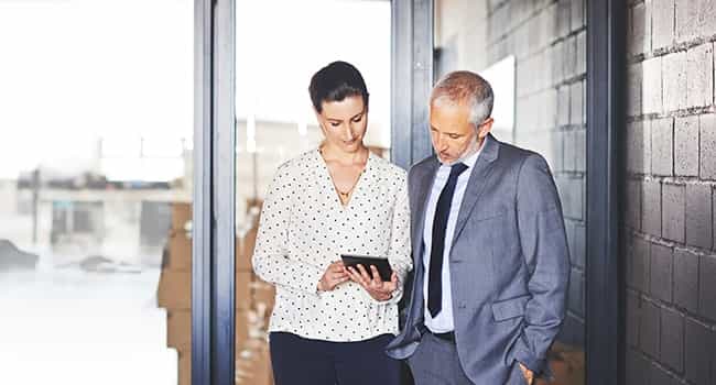 a property manager reviews a real estate contract on a tablet with a property owner