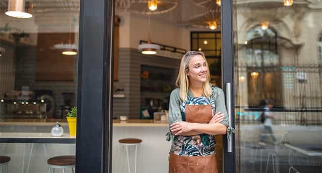 a restaurateur stands in the doorway of a modern cafe