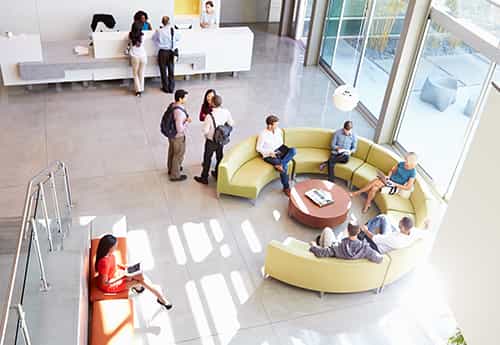 aerial view of an office building lobby where investors and real estate advisors discuss market trends