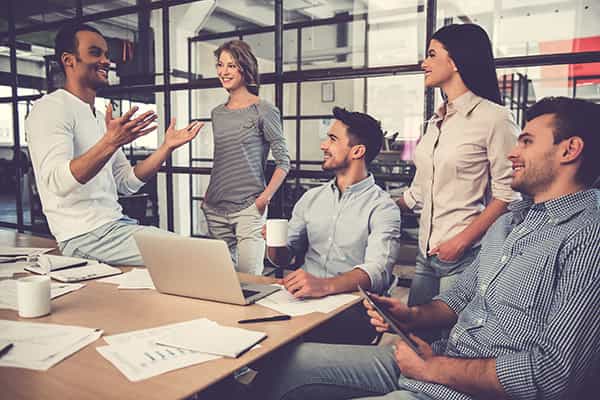 An image of a group of young professionals talking around a desk