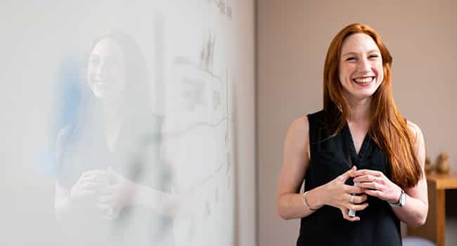 Image of a woman presenting an idea on a whiteboard