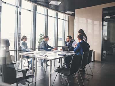 An image of a group of people talking around a desk