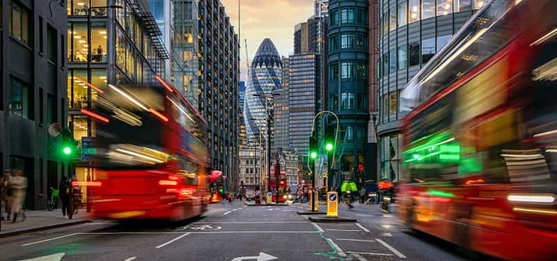 An image of London City with two London red buses in the foreground