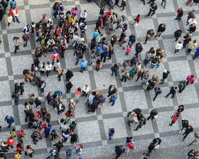 An aerial image of a group of people walking through a busy town square