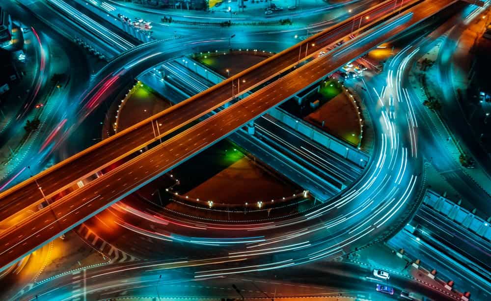 An aerial image of a traffic roundabout at night, lit by street lighting