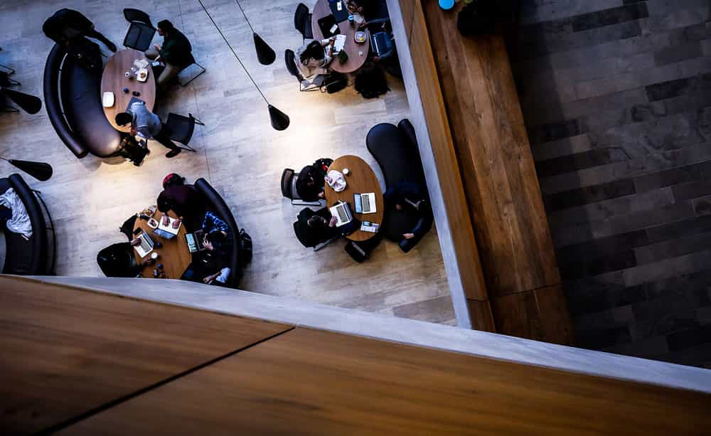 An image of a group of desks with people sitting around, in a co-working space