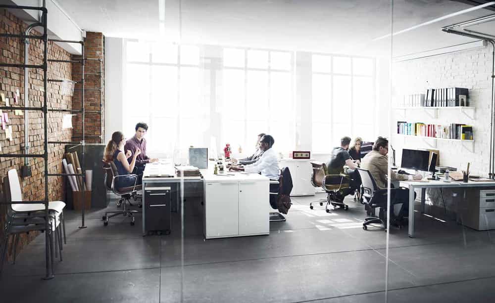 An image of an office with a group of people working on computers