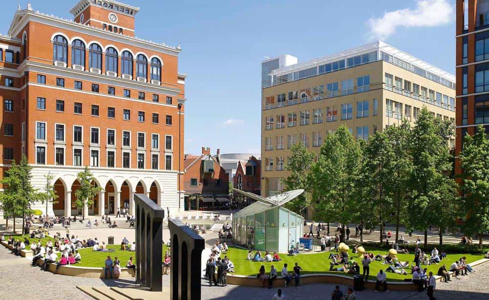 An image of Brindleyplace on a hot summers day, showing office buildings, the central square, and people sitting out in the sun