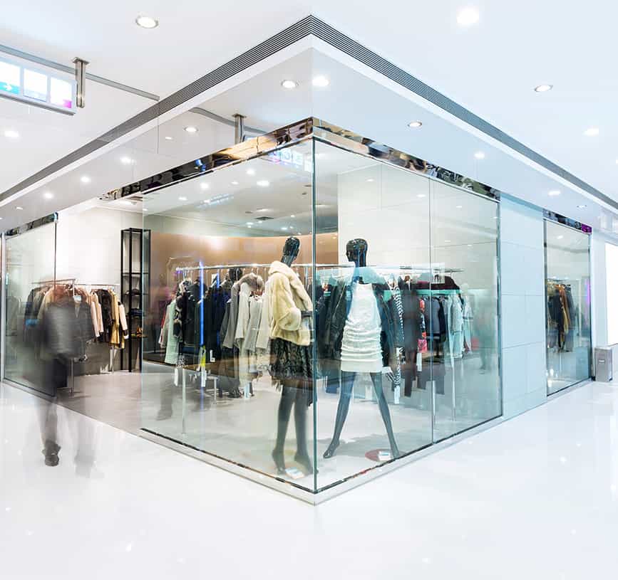 An image of a modern retail store within a shopping mall showing black mannequins