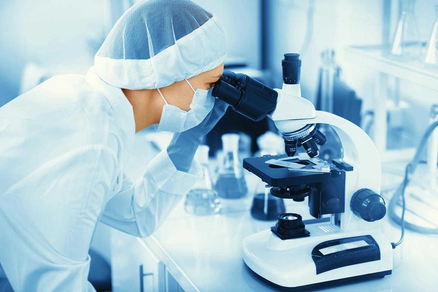 An image of a scientist looking through a microscope