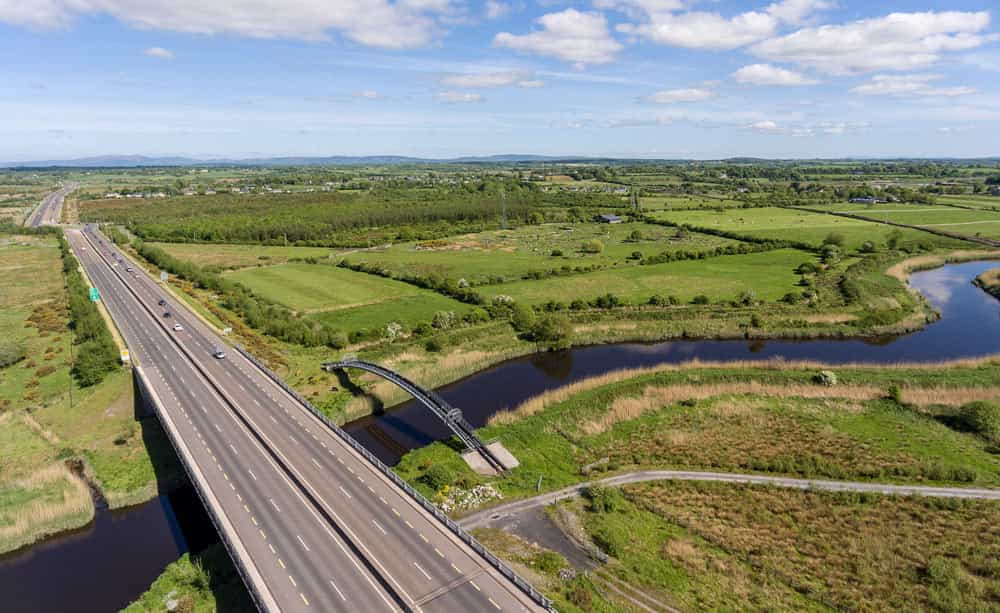 An aerial image of a highway passing next to green fields