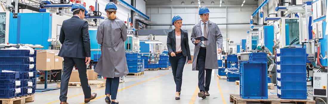 Industrial real estate broker tours manufacturing facility discussing market statistics